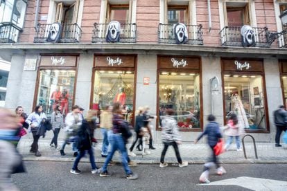 Varias personas pasan por delante de una tienda del centro de Madrid el 31 de octubre.