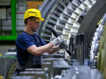 Un empleado comprueba el ajuste de un componente en la línea de montaje de la fábrica de turbinas de gas de Siemens AG, en Berlín, en una imagen de archivo.