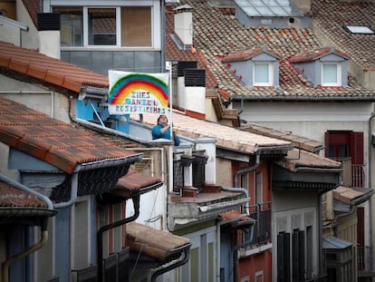 Una persona coloca en su terraza el dibujo de un arcoíris solidario con los nombres de sus hijos en el casco histórico de Pamplona.