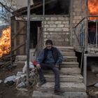 In this image released by World Press Photo, Thursday April 15, 2021, by Valery Melnikov, Sputnik, part of a series titled Paradise Lost, which won the first prize in the General News Stories category, shows Areg sits outside a burning house in the village of Karegakh, Nagorno-Karabakh, on 25 November. Some village residents burned their houses before leaving areas that were to return to Azerbaijani control following the November peace agreement. (Valery Melnikov, Sputnik, World Press Photo via AP)