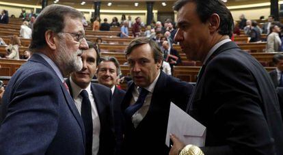El presidente del Gobierno, Mariano Rajoy, conversa con algunos de sus diputados en el pleno de Presupuestos.