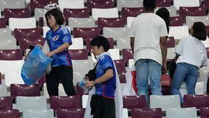 Aficionados japoneses recogen sus desperdicios en el estadio tras la victoria de su selección ante Alemania.
