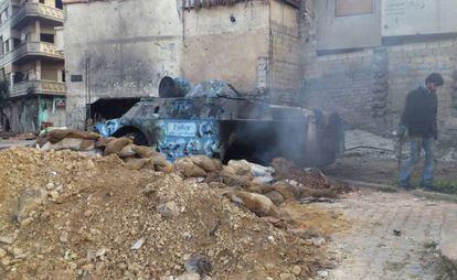 Los restos de un blindado de la polic&iacute;a siria incendiado durante los combates entre el Ej&eacute;rcito y los rebeldes, el pasado s&aacute;bado en el barrio de Jaldiya, en Homs.