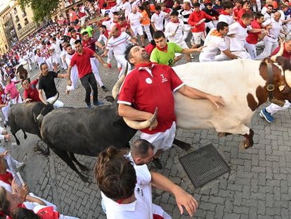 Un toro de la ganadería de Miura arrolla a un mozo en el octavo y último encierro de Sanfermines, este viernes en Pamplona.