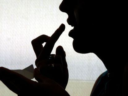 Joven consumiendo una droga sint&eacute;tica con la yema de los dedos.