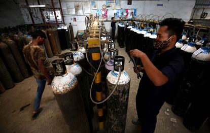 Operarios preparan botellas de oxígeno en Bangalore (India).