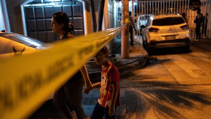 Habitantes de Durán (Ecuador) cruzan la cinta que rodea una escena del crimen para llegar a casa, el 28 de septiembre.