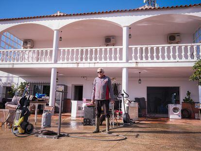 José Luis Fernández, vecino del anejo de Gévora (Badajoz), posa en la fachada de su casa junto a algunos de los muebles y electrodomésticos que ha podido rescatar tras las inundaciones.