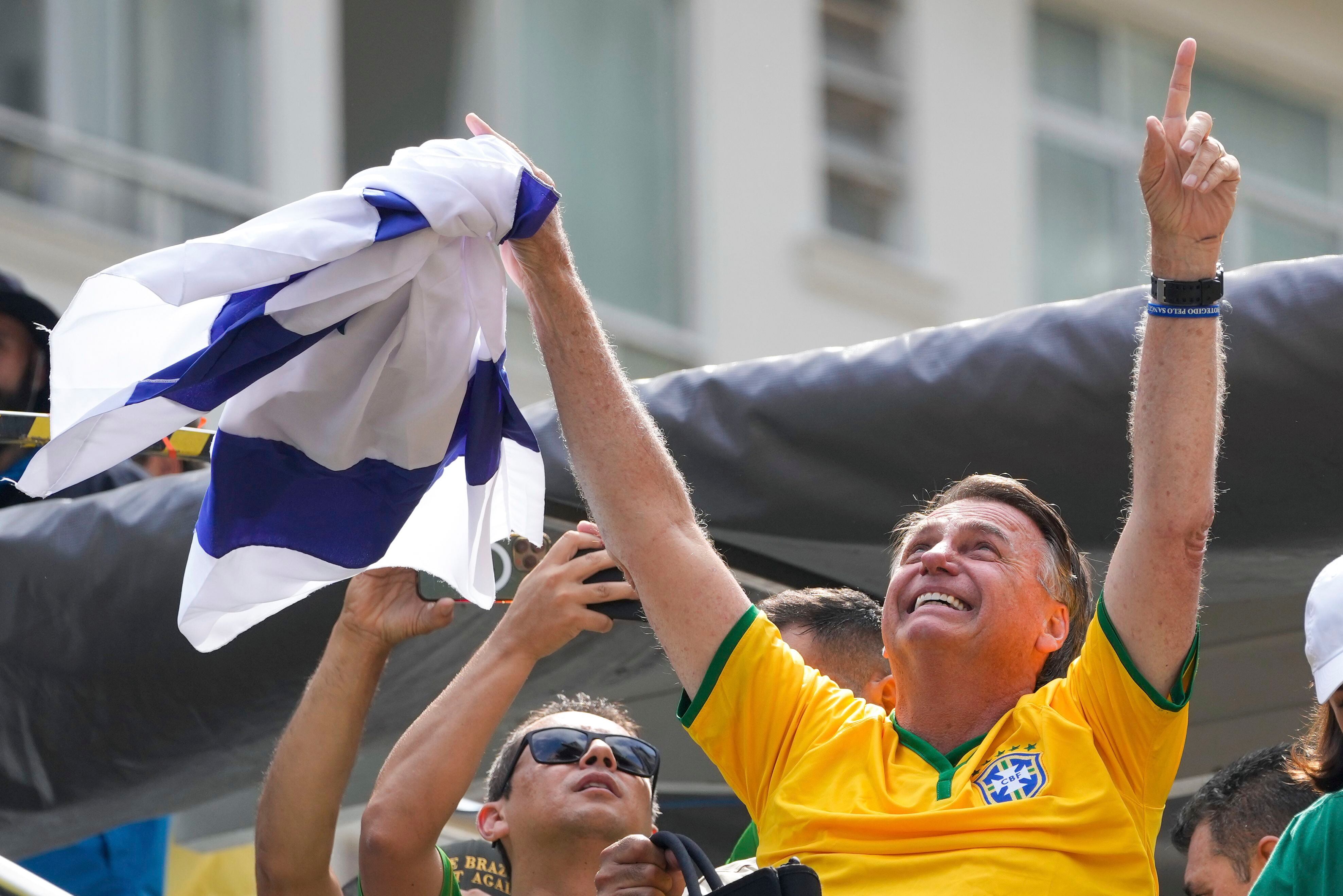 Jair Bolsonaro celebra con la camiseta de la selección nacional de fútbol de Brasil.
