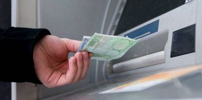 Un hombre saca euros de un cajero autom&aacute;tico.