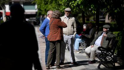 Un grupo de personas mayores conversando en un parque, en Sevilla.