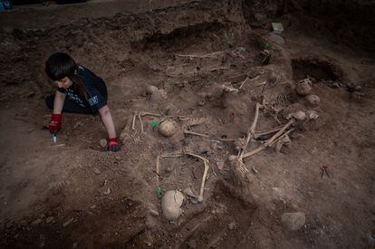 Una arqueológa trabaja en la fosa común hallada en el cementerio de Belchite (Zaragoza), en octubre de 2021.