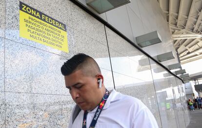 Un cartel anuncia multas a los chóferes de taxis de plataformas digitales que aborden pasajeros afuera del AICM, el 26 de junio de 2022.