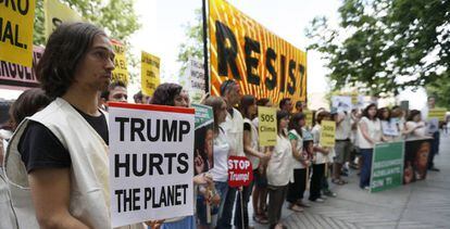 Participantes en la concentración convocada por Greenpeace frente a la Embajada de Estados Unidos para protestar por la decisión del presidente de Estados Unidos, Donald Trump, de sacar a su país del Acuerdo de París.