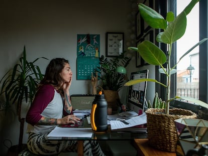 Una mujer realiza teletrabajo en su casa.