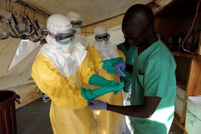 Miembros de la ONG Médicos sin fronteras se ponen los guantes y las máscaras para aislarse del virus y evitar el contagio.