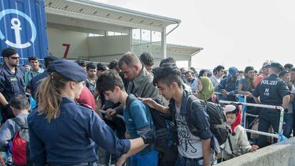 Refugiados pasan un control policial en Austria a su llegada desde Hungr&iacute;a. 