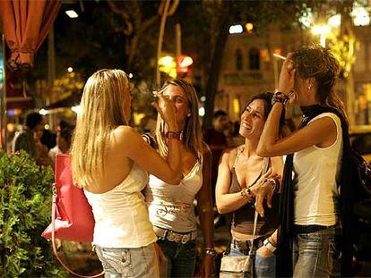 Un grupo de jóvenes fuma en una calle de Barcelona antes de entrar a una sala de fiestas.