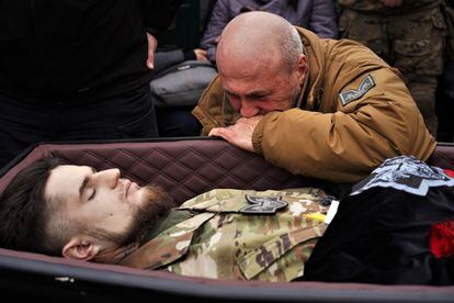 Un soldado llora sobre el féretro de su compañero Dmitro Kotsiubailo durante su funeral en Kiev. 