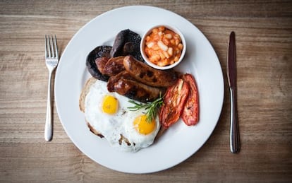 Desayuno ingl&eacute;s cl&aacute;sico: huevos, beicon, salchichas y alubias con tomate.