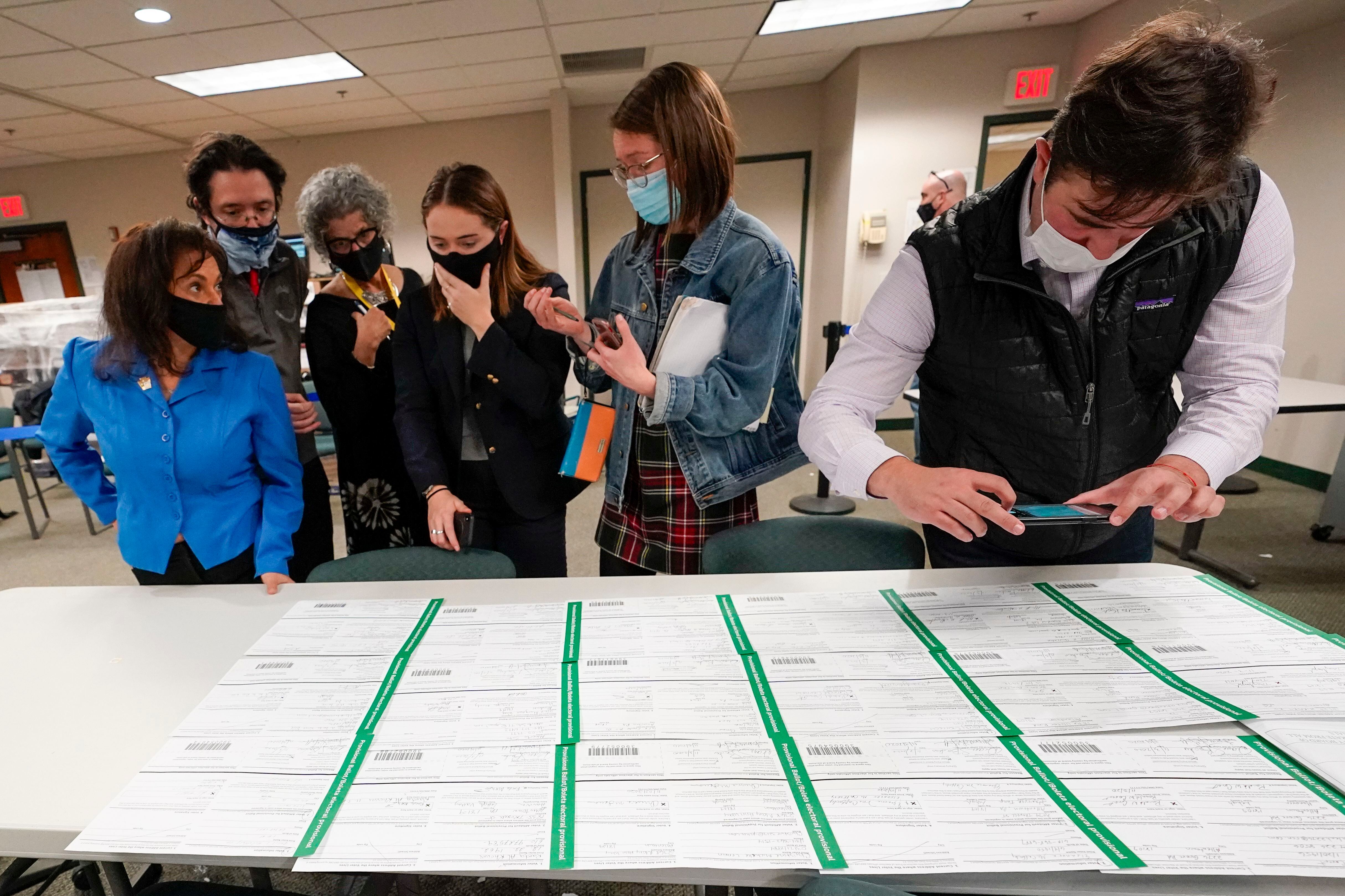Observadores demócratas y republicanos inspeccionan las papeletas del condado de Lehigh mientras continúa el conteo de votos en las elecciones generales, el viernes 6 de noviembre, en Allentown (Pensilvania).