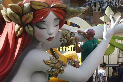 Artistas fogueros dando los últimos retoques a una hoguera de hace dos años.