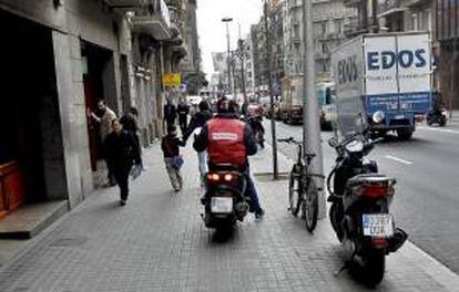 Un motociclista conduce por la acera de la calle Balmes de Barcelona. EFE/Archivo