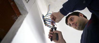 Un electricista maneja una instalación eléctrica durante la reforma de una vivienda.