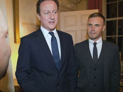 El primer ministro brit&aacute;nico David Cameron con  Gary Barlow, cantante y compositor principal del grupo.