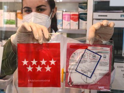 Una farmacéutica muestra las mascarillas KN95 que se reparten gratis en las farmacias de Madrid, el pasado lunes.