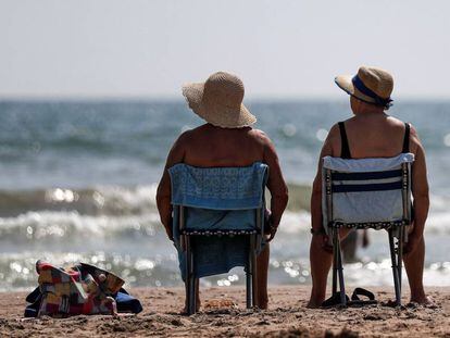 Dos mujeres toman el sol en la playa de La Malvarrosa de Valéncia.