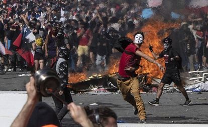 Un joven lanza piedras contra la policía durante una protesta en Santiago de Chile.