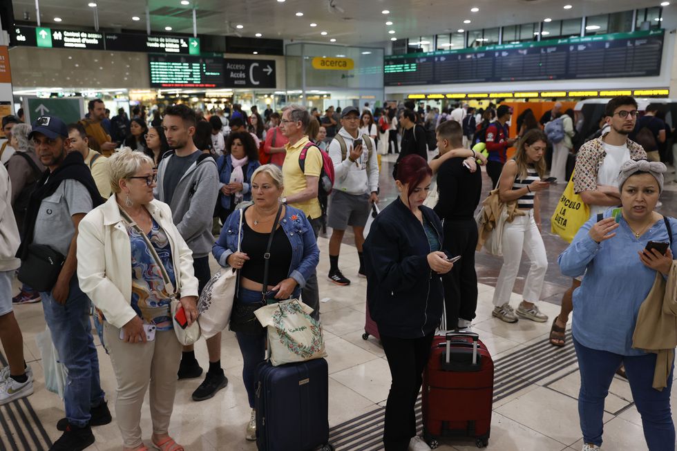 Decenas de viajeros esperan en la estación de Sans, este domingo en Barcelona. 