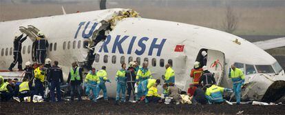 Bomberos y trabajadores de los servicios de emergencias holandeses auxilian a los pasajeros del avión que se ha partido en tres al aterrizar en el aeropuerto de Schiphol.
