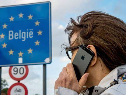 Una dona fa servir el seu mòbil a la frontera entre França i Bèlgica.