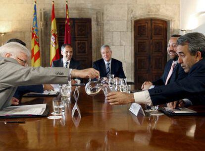 El presidente de Murcia, Ramón Luis Valcárcel y el de Valencia, Francisco Camps, ambos al fondo, observan a sus consejeros de Medio Ambiente en la reunión que han celebrado en el Palau de la Generalitat.