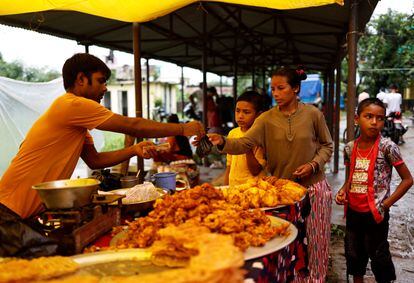 Madre e hijos acuden juntos a comprar comida en el mercado local. 