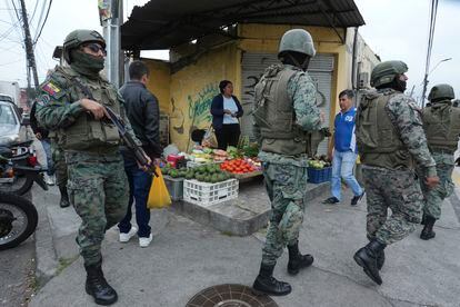 Soldados patrullan el perímetro de la prisión El Inca durante un estado de emergencia mientras un vendedor de alimentos trabaja en la acera, en Quito. El Gobierno también impuso un toque de queda desde las 23:00 a 05:00 horas.