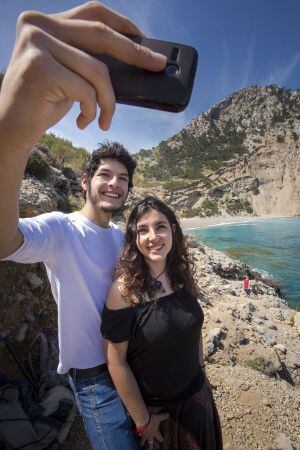 Una pareja se retrata con el móvil en la playa de Coll Baix, en Alcúdia (Mallorca).