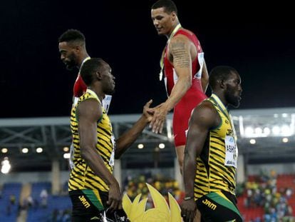 Desde lo alto del podio, Ryan Bailey saluda a Usain Bolt tras el mundial de relevos de Bahamas.