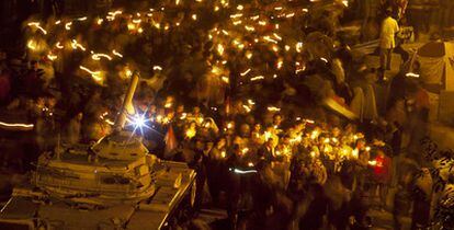 Manifestantes anti-Mubarak desfilan con velas ante un tanque en la plaza cairota de la Liberación.