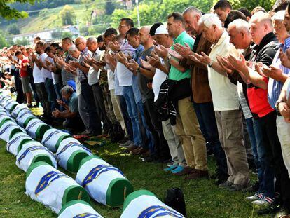 Musulmanes bosnios rezan frente a los cuerpos de 33 hombres recientemente identificados como víctimas de Srebrenica, el pasado 11 de julio de 2019.