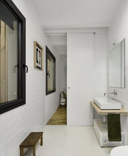 En el baño, blanco y con encimera de madera, el lavabo rectangular es un producto de la empresa Alape.