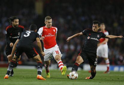 Wilshere protege el balón ante tres rivales.