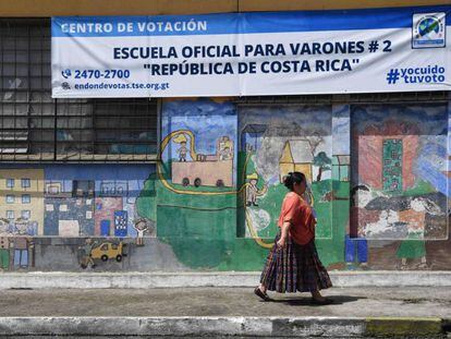 Una mujer camina ante un centro de votación en Ciudad de Guatemala.