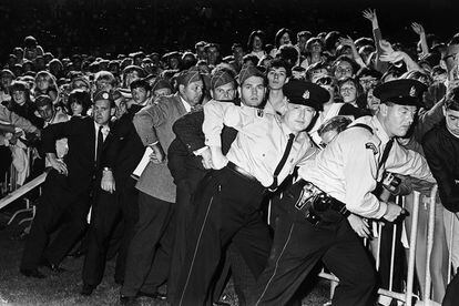 Agentes de policía sosteniendo a la marabunta en Vancouver. Algunos de ellos tenían que ser atendidos tras recibir "mordiscos" de las seguidoras histéricas.