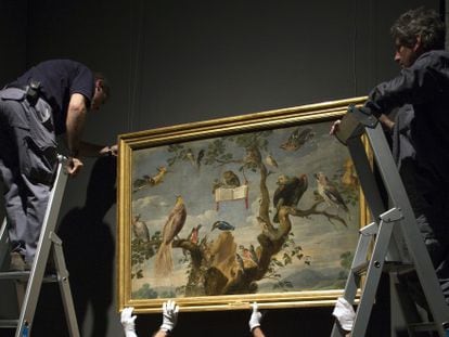 Un grupo de operarios, con un cuadro del Museo del Prado. 