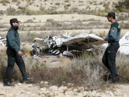 Dos agentes de la Guardia Civil junto a los restos del ultraligero siniestrado en Mutxamel.