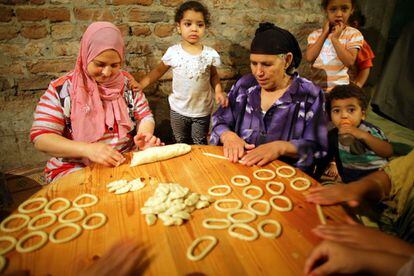 Mujeres egipcias preparan Kahk, galletas de mantequilla elaboradas en un horno tradicional sin puerta en la villa de Dalgamon (Egipto). Los egipcios musulmanes se preparan para celebrar el Eid al-Fitr, un festival religioso que marca el fin del mes del Ramadán. 