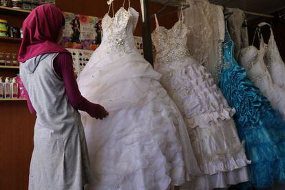 Una joven siria de 14 a&ntilde;os elige su vestido de boda en el campo de refugiados de Za&#039;atari, en Jordania. 